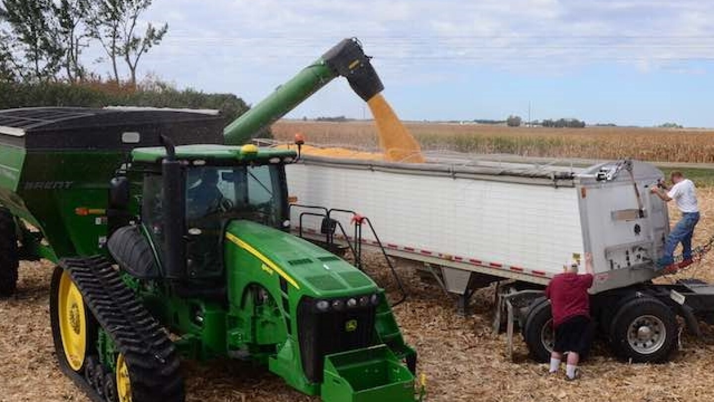 Farm machinery working across a harvested field.